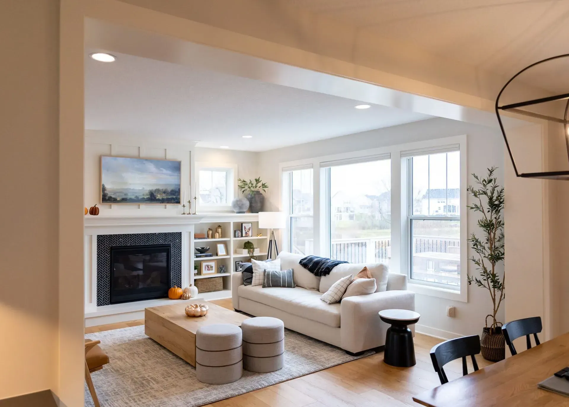 Living room with fireplace, white sofa, and large windows.