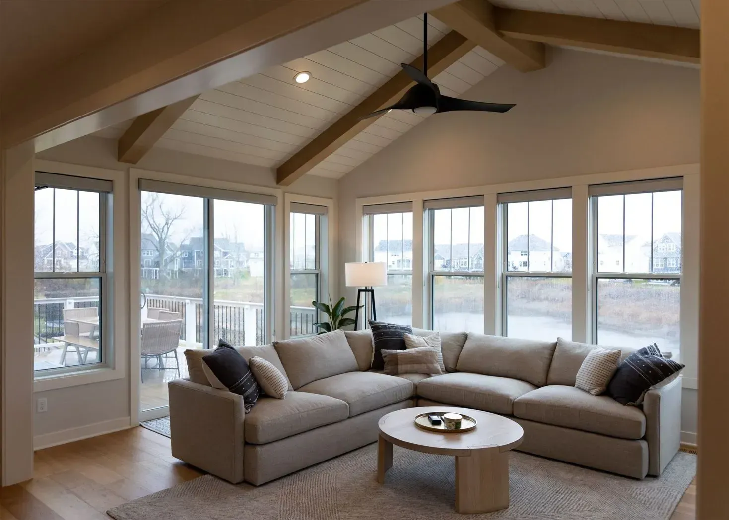 Living room with a large sectional sofa, round coffee table, and large windows.