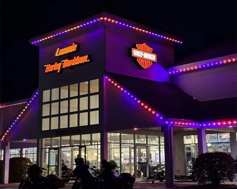 Illuminated Twin Peaks restaurant at night with purple neon lights and glass front
