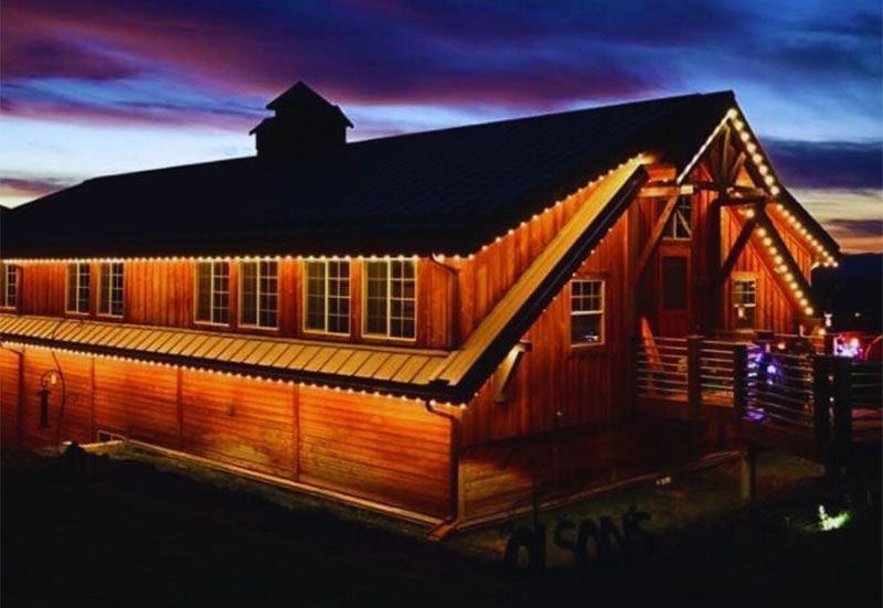 Wooden lodge lit warmly at dusk under a purple sky