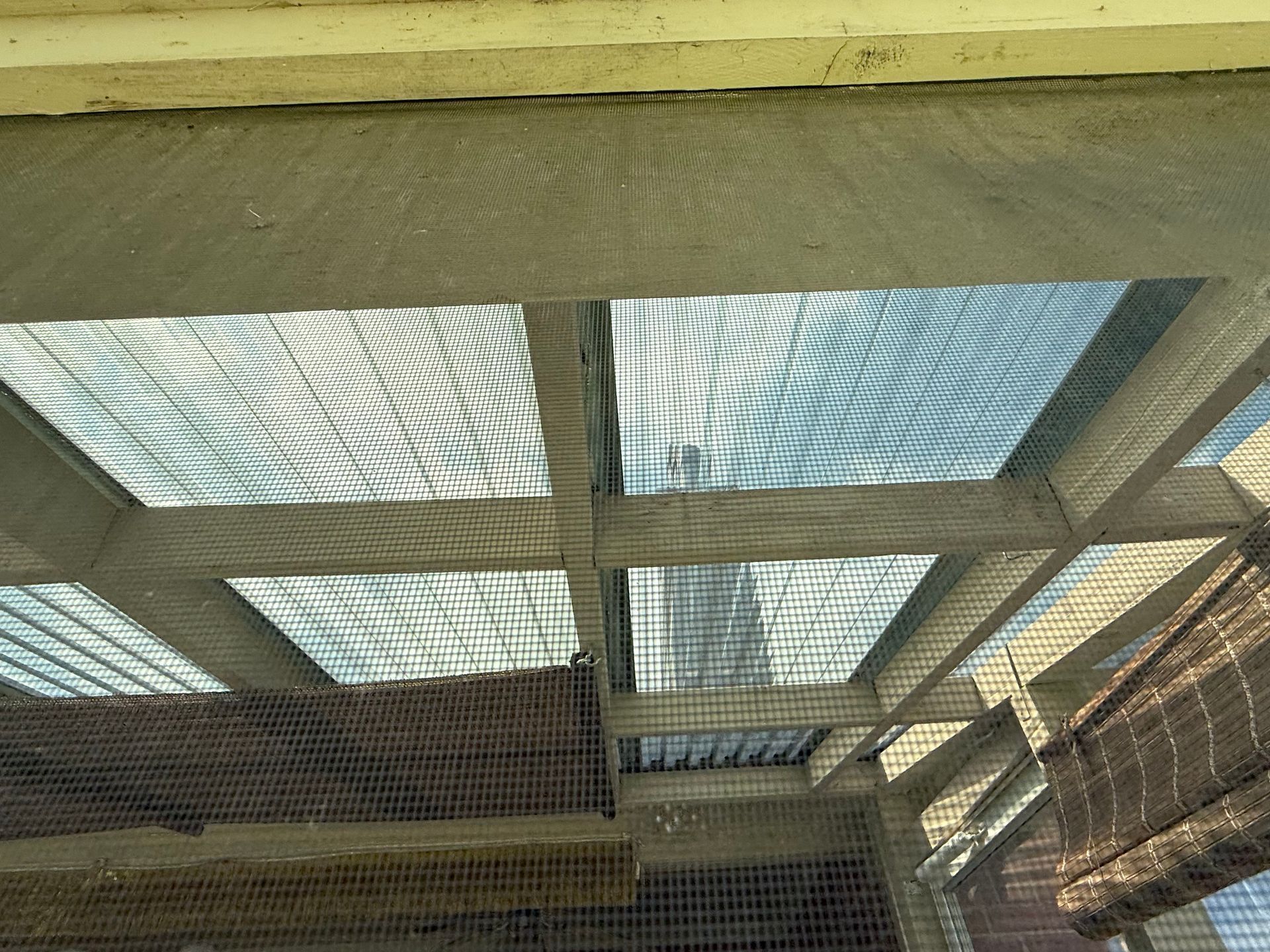 Wooden framed roof panels covered in netting, casting shadows.