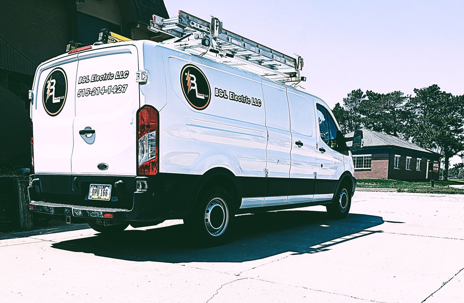 A white van with a ladder on top of it