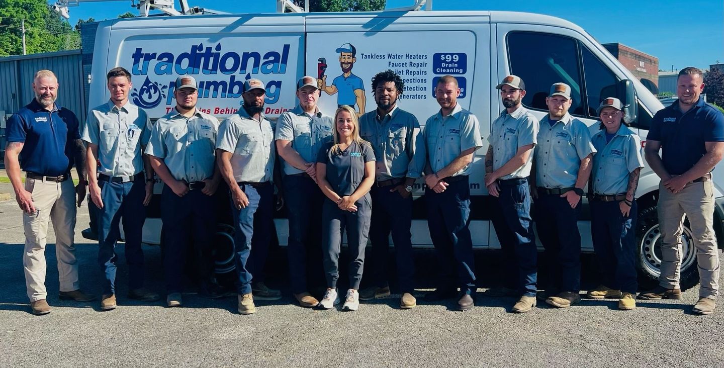 A group of people standing in front of a van that says traditional plumbing.