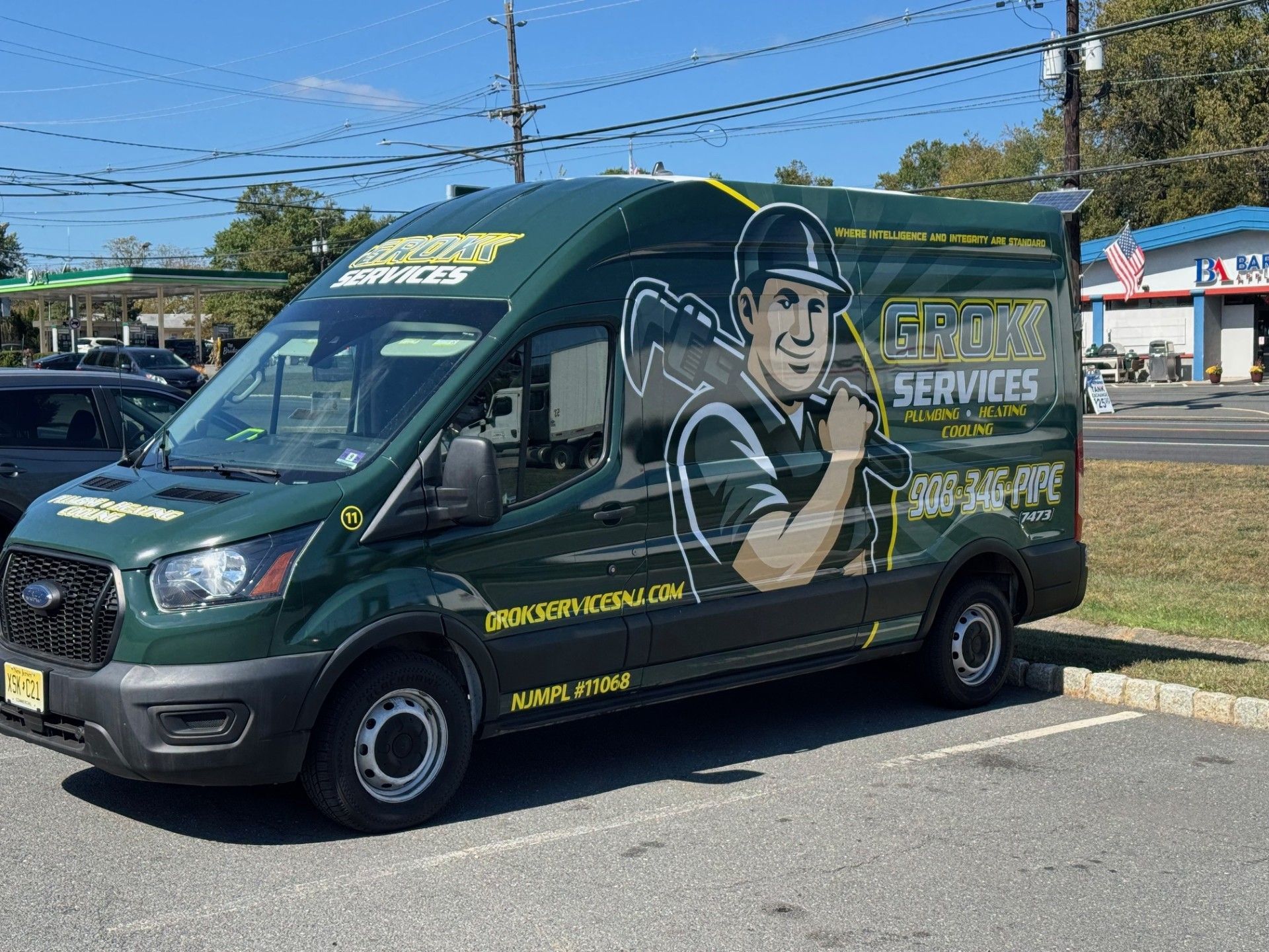 Green van with logo, parked outside. Cartoon man holding bat, 