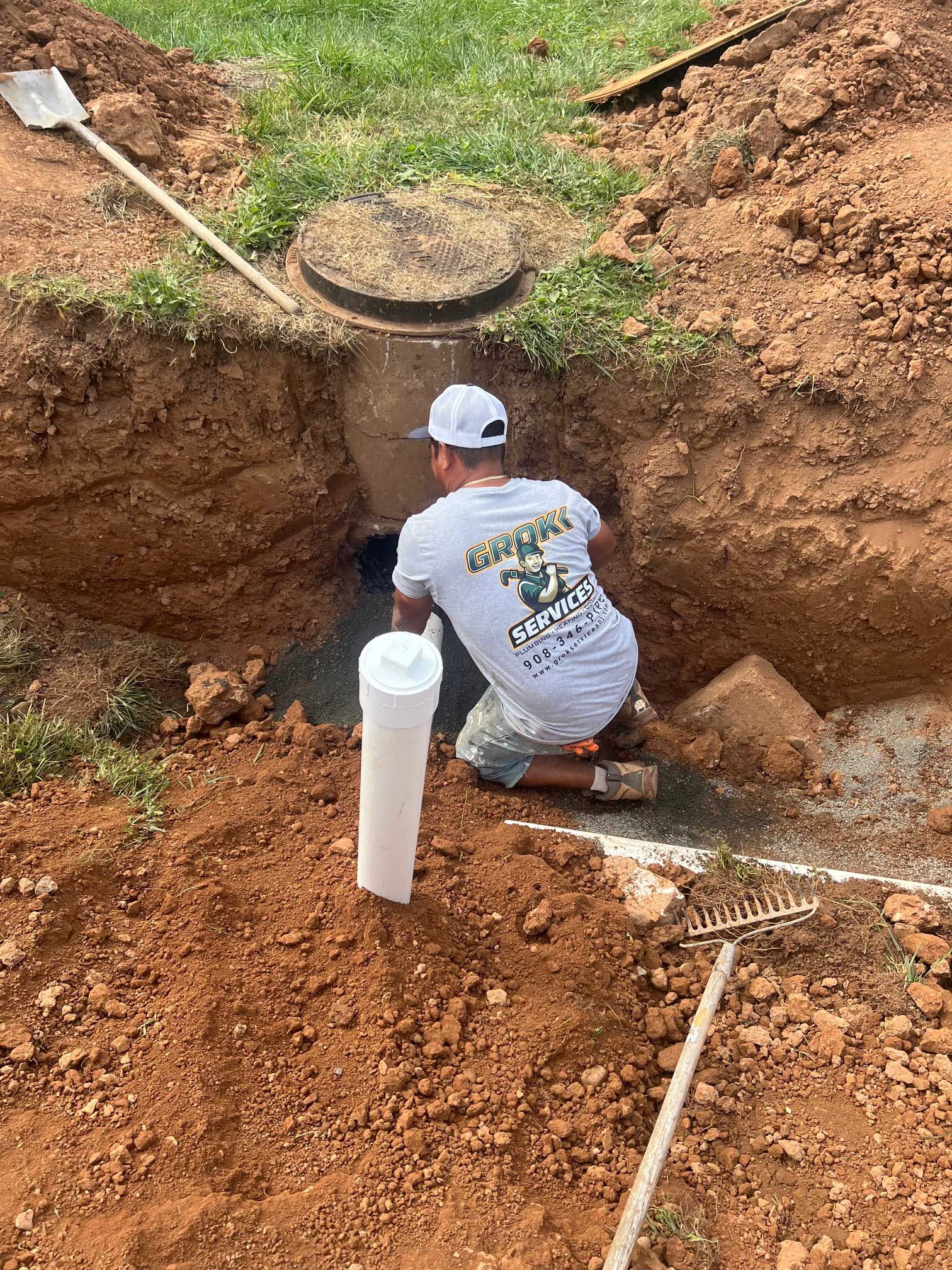 a man working on a septic tank, in a trench