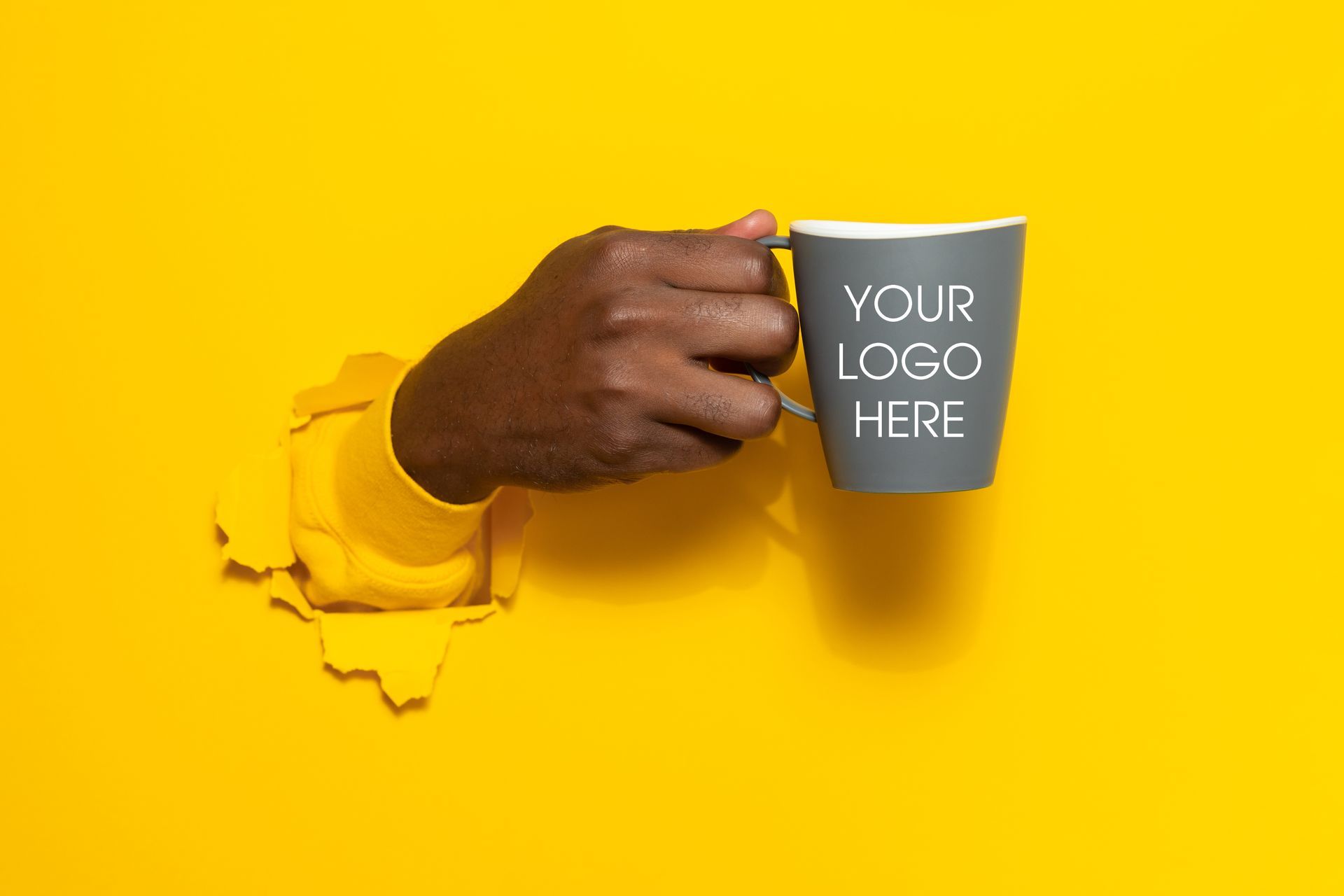 Hand holding a gray mug with 
