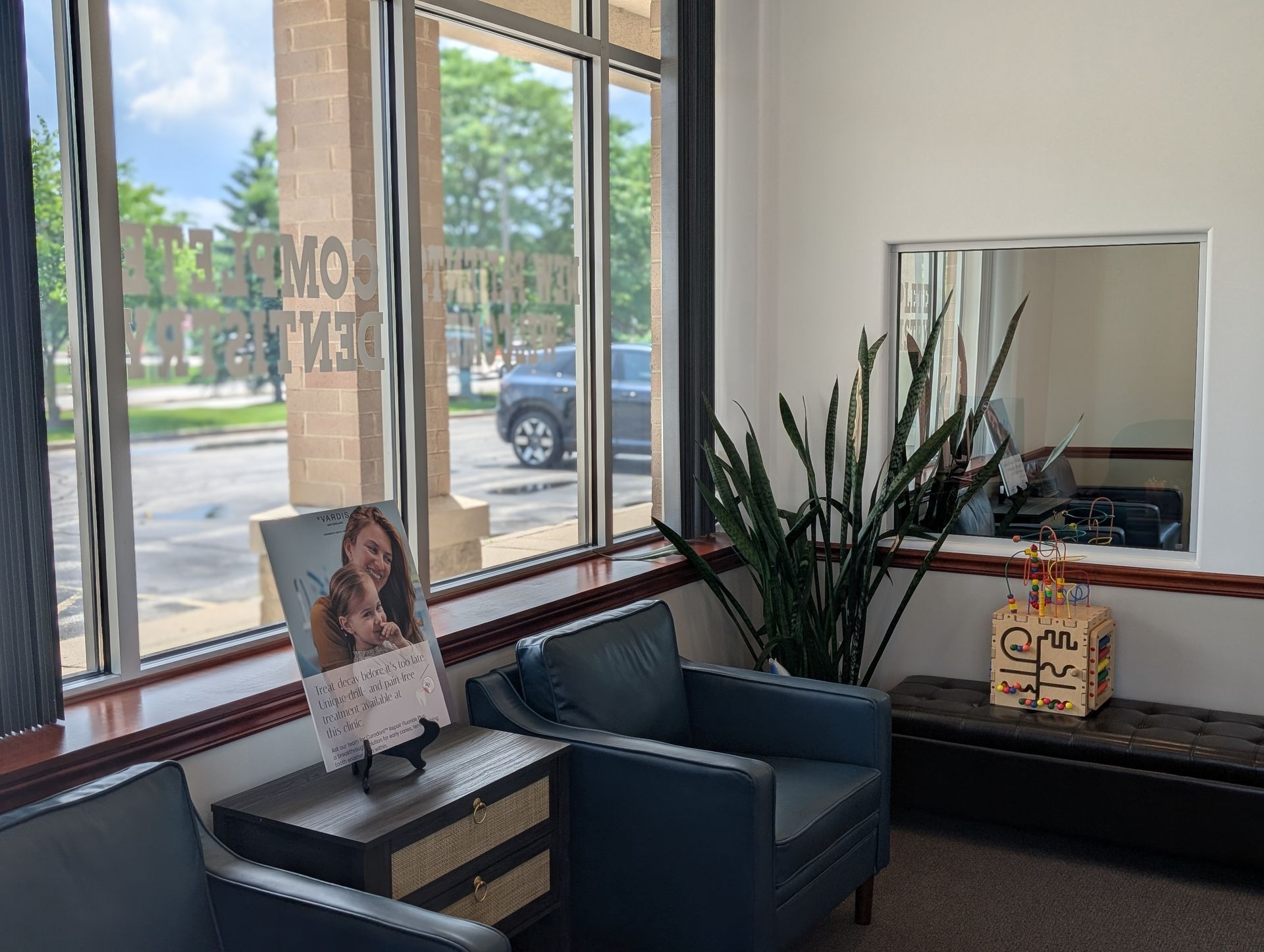 A waiting room with two chairs, a table, and a mirror.