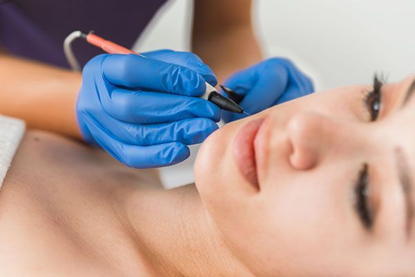 A woman is getting a facial treatment at a beauty salon.