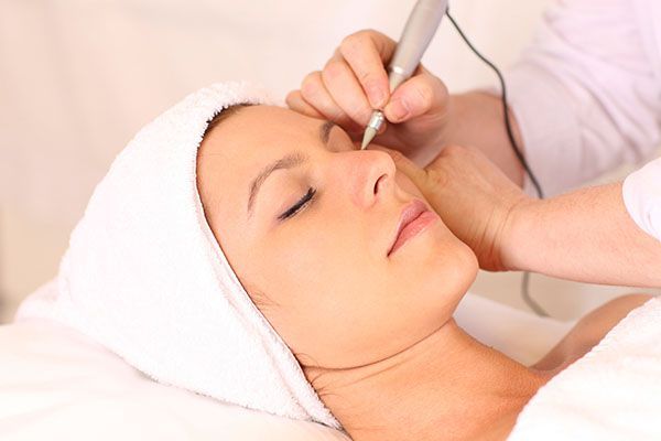 A woman is getting a tattoo on her eyebrows.