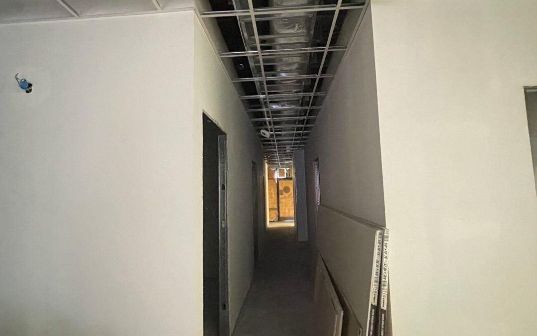 A long hallway with a ceiling that is being built in a building.