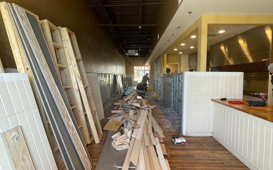 A building under construction with a lot of wood stacked on the floor.