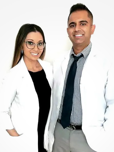 A man and a woman in white coats and ties are standing next to each other.