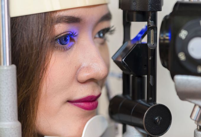 A woman is getting her eyes examined by an ophthalmologist.