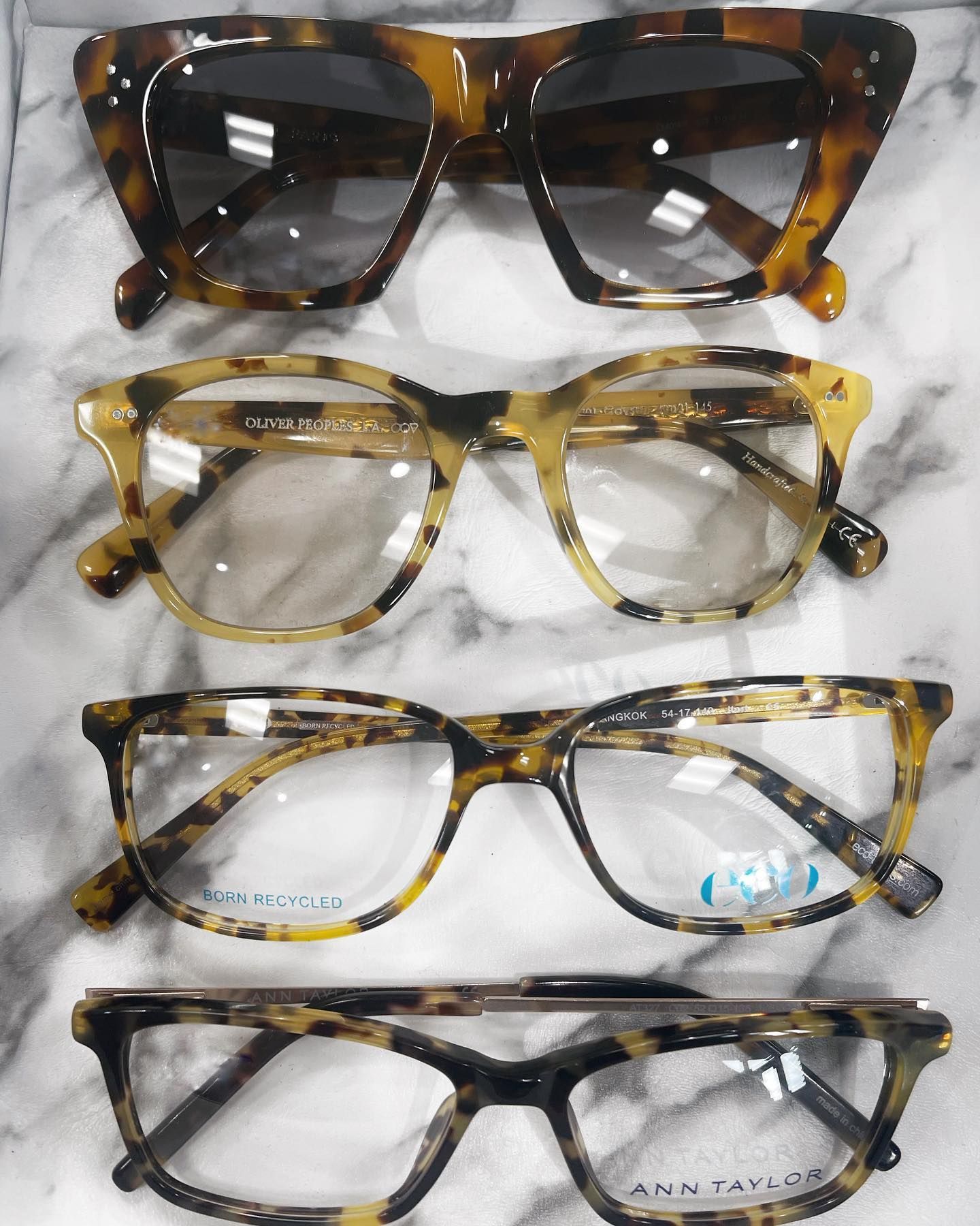 Four pairs of glasses are lined up on a marble surface