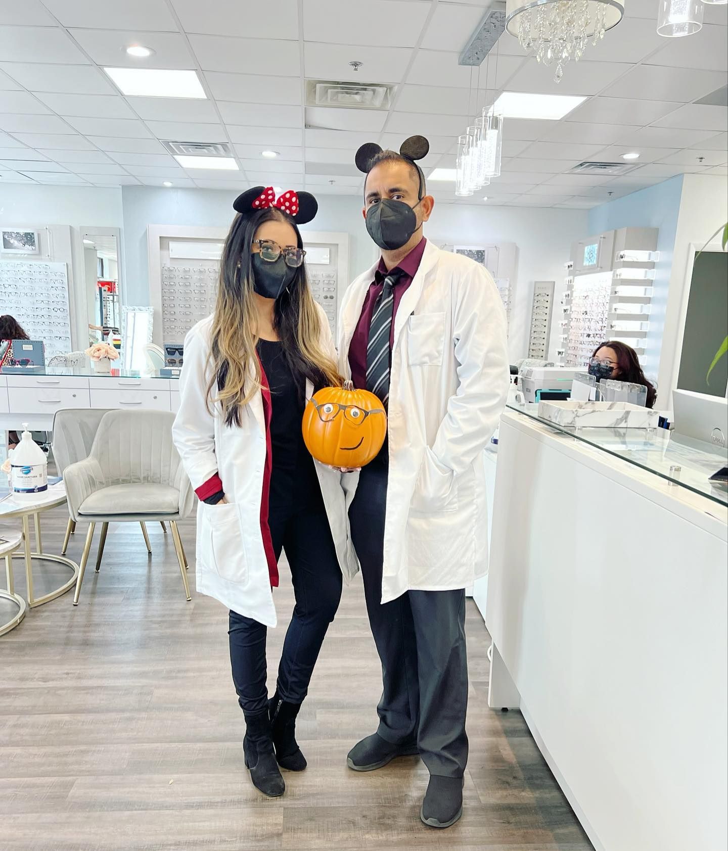 A man and a woman wearing masks are standing next to each other in a store holding a pumpkin.