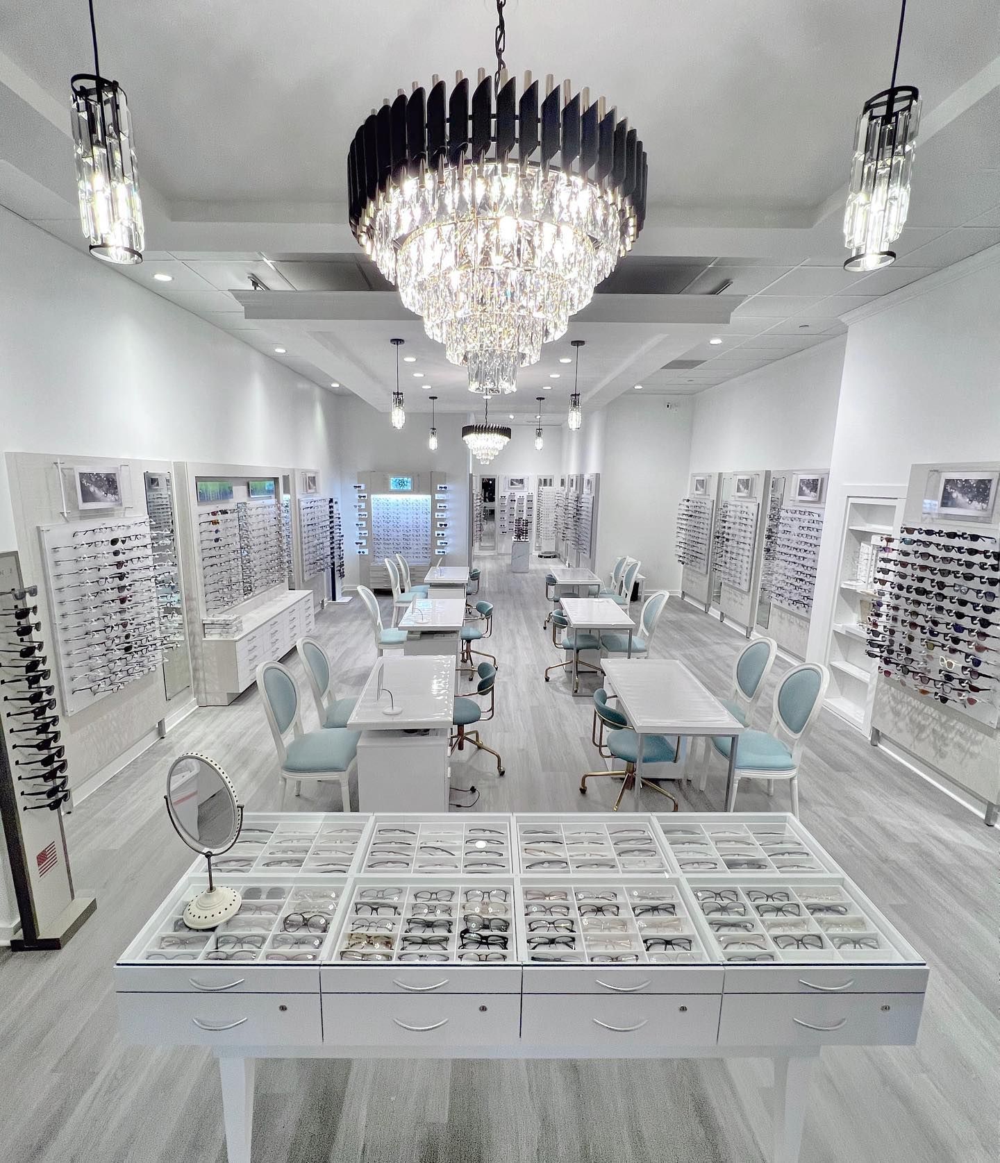 A large white room with a chandelier hanging from the ceiling.