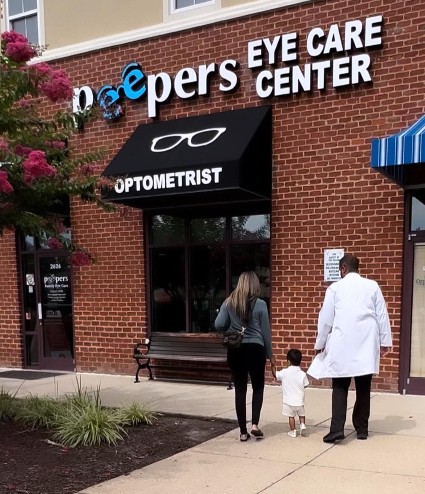 People walking in front of a peepers eye care center