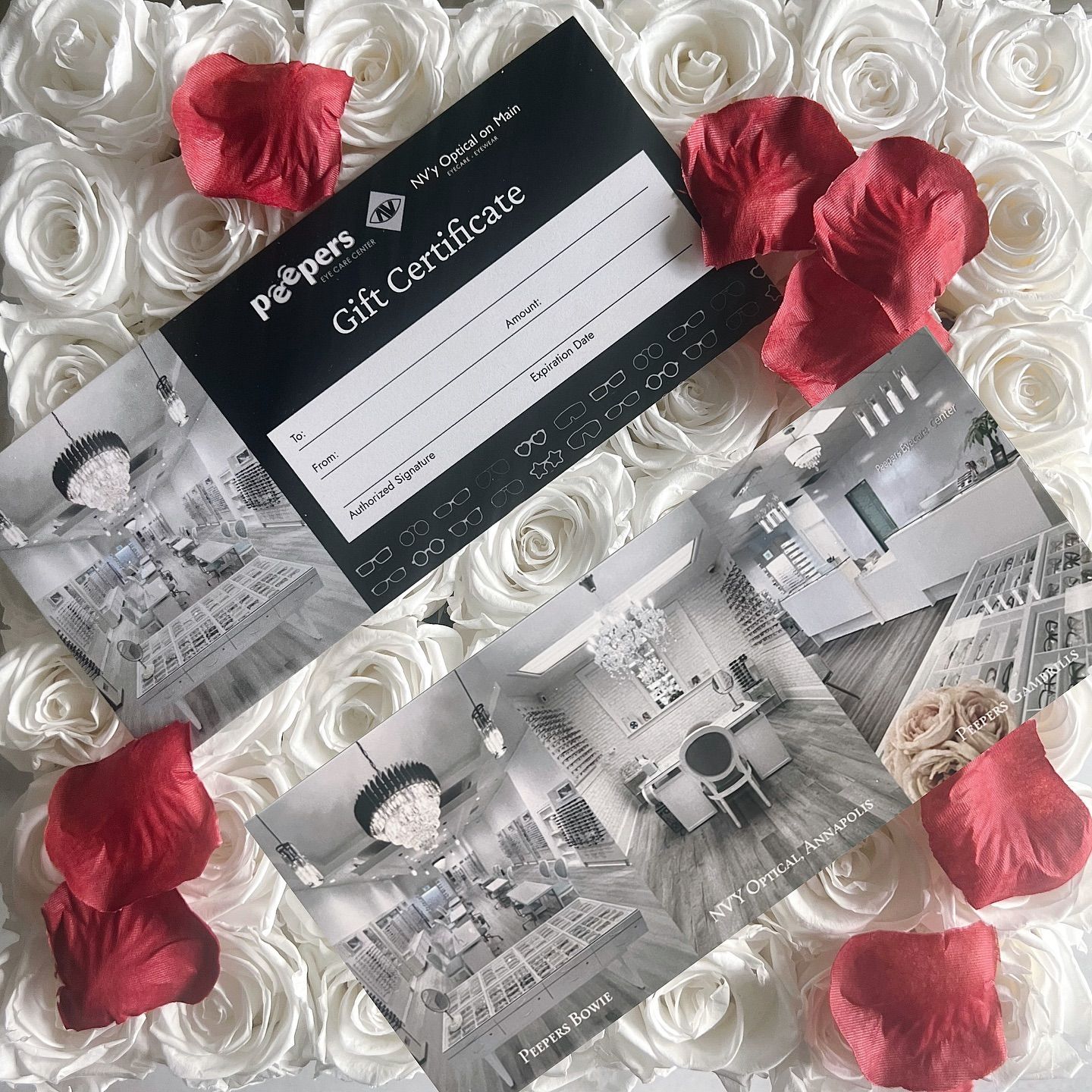 A gift certificate is sitting on top of a bed of roses.