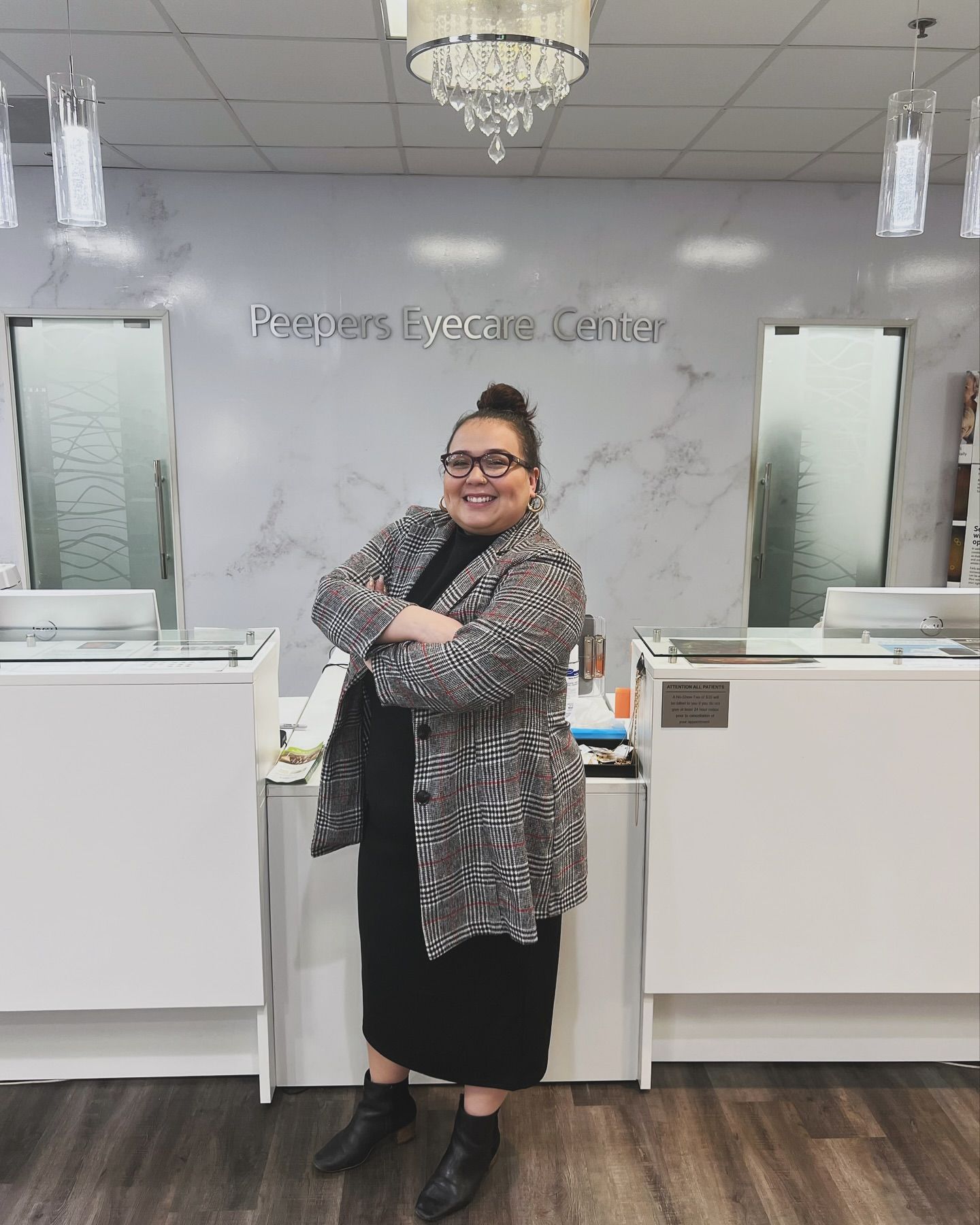 A woman is standing in front of a counter in a store.