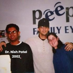 Three people posing for a picture in front of a sign