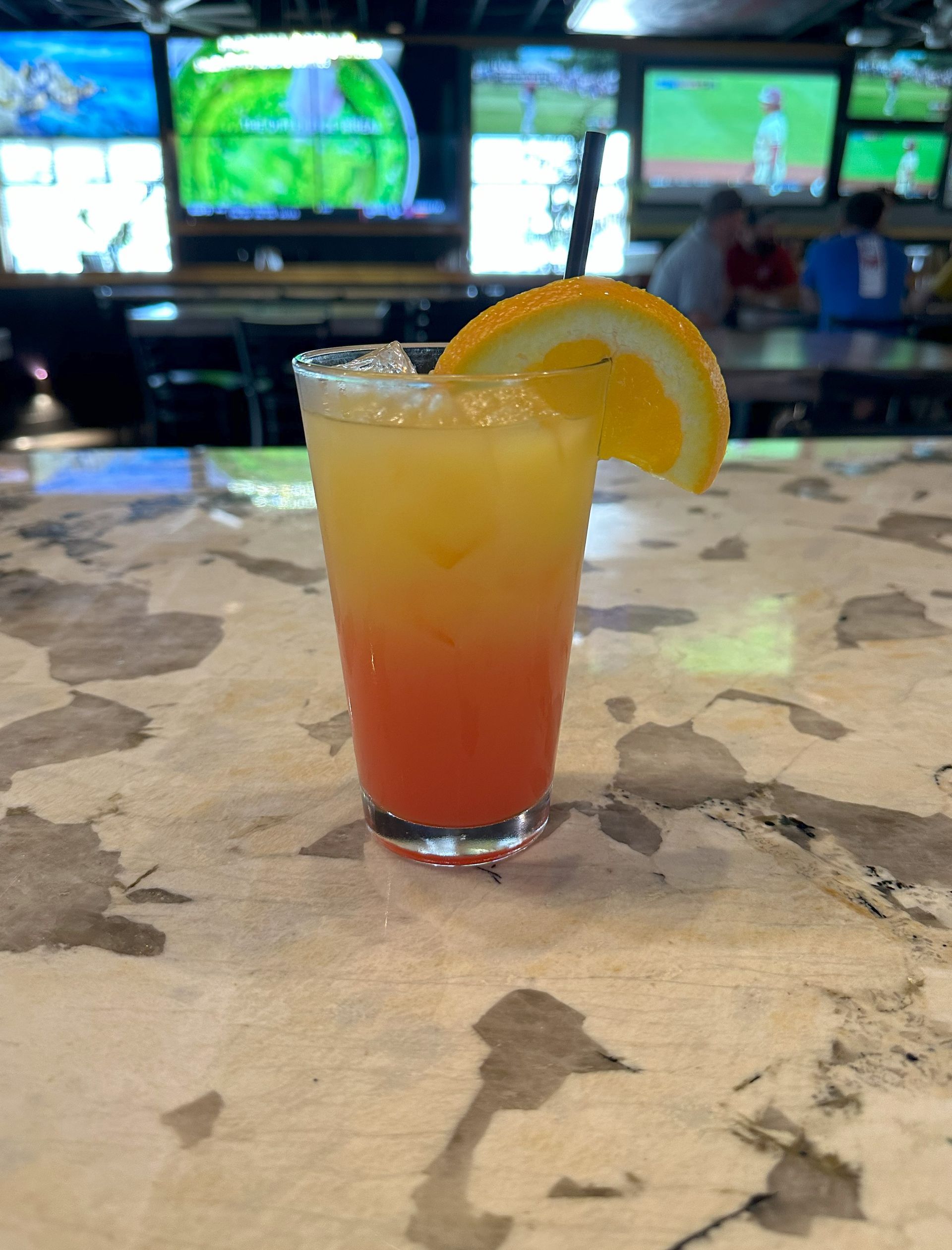 A close-up of a drink with an orange slice on a table