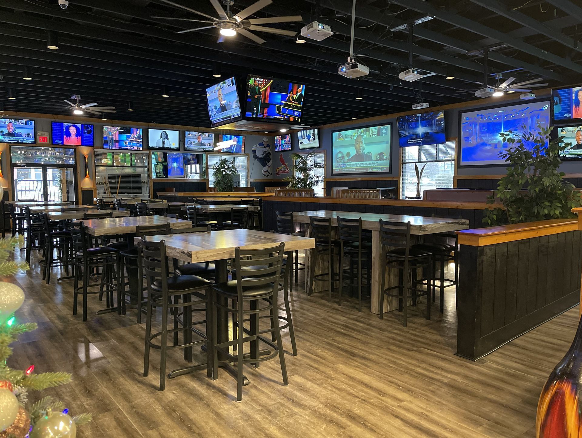 A large room filled with tables and chairs and televisions.