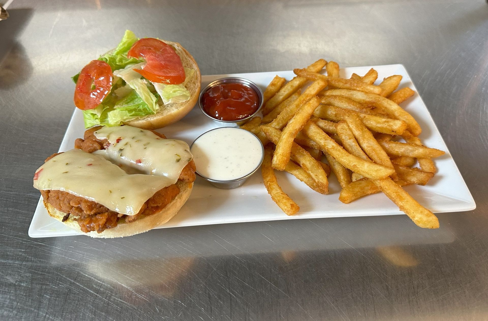 A white plate topped with a chicken sandwich and french fries.