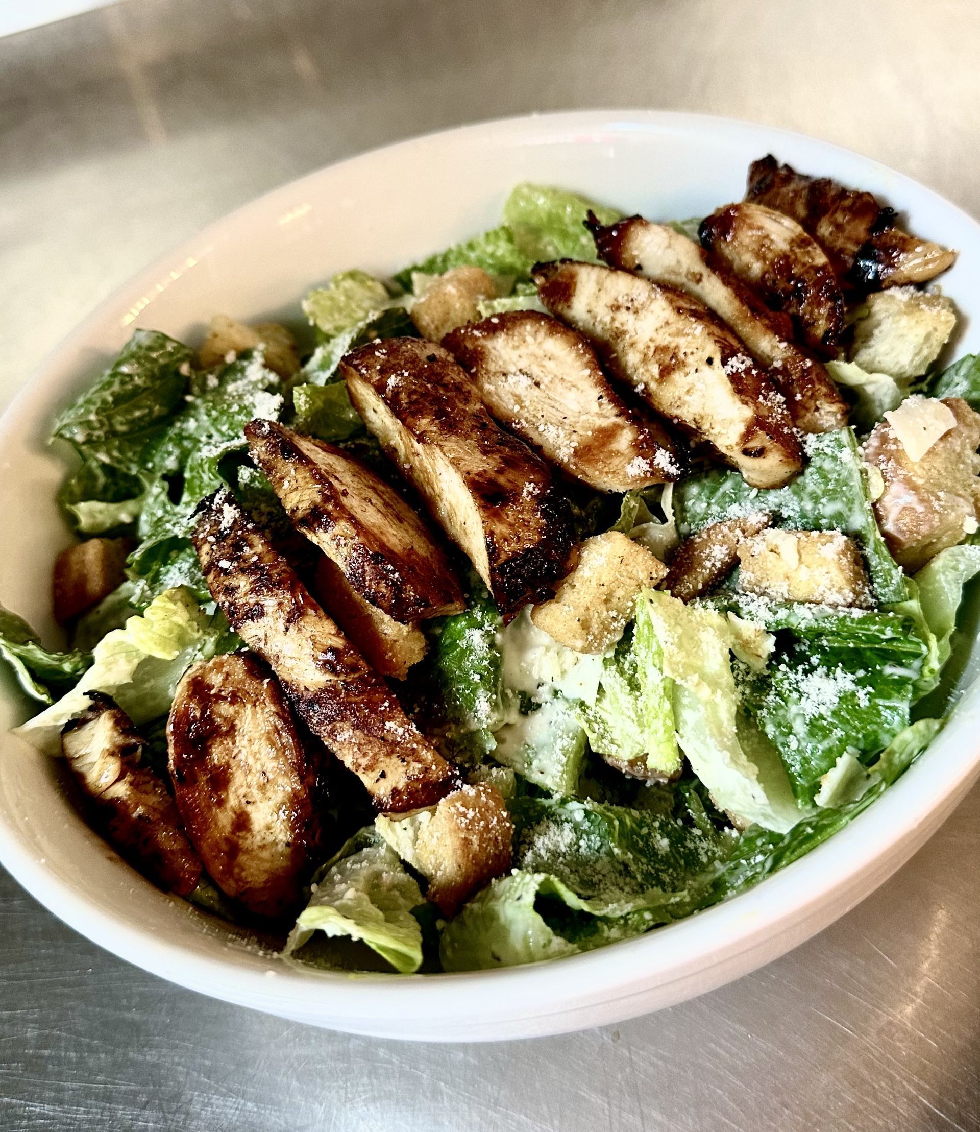 A close up of a salad with chicken and lettuce in a bowl