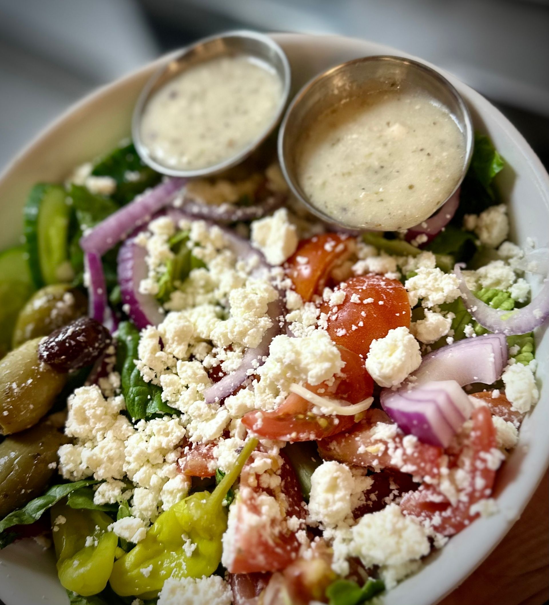 A close up of a salad with two dipping sauces