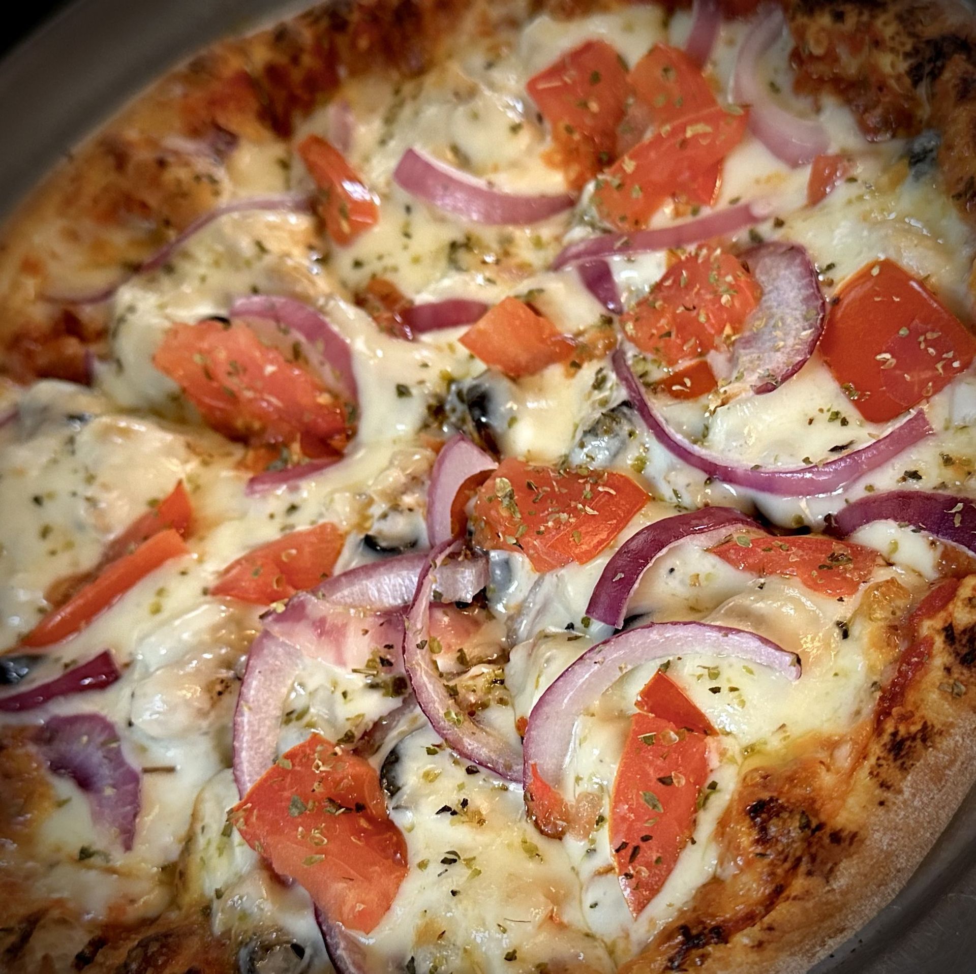 A pizza with tomatoes and onions on it