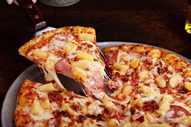 A pizza is sitting on top of a wooden cutting board