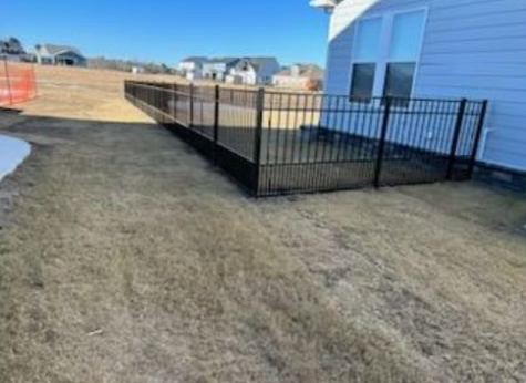 there is a fence around the backyard of a house