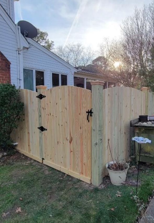 a wooden fence with a gate in the backyard of a house
