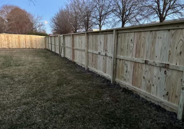 a wooden fence is sitting in the middle of a grassy yard