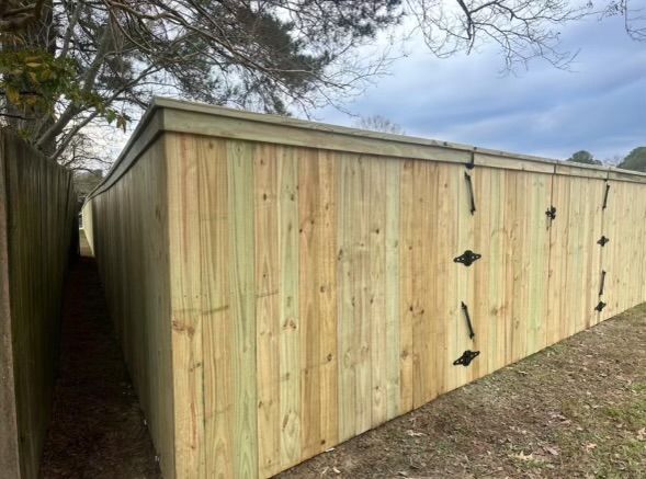 a wooden fence with a gate in the middle of a yard