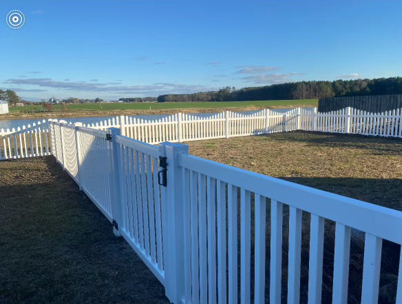 a white picket fence with a gate in a yard