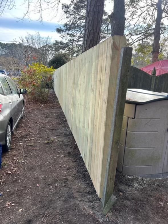 a car is parked next to a wooden fence