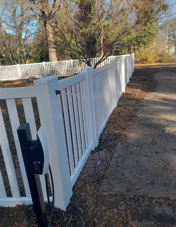 a white fence along the side of a road