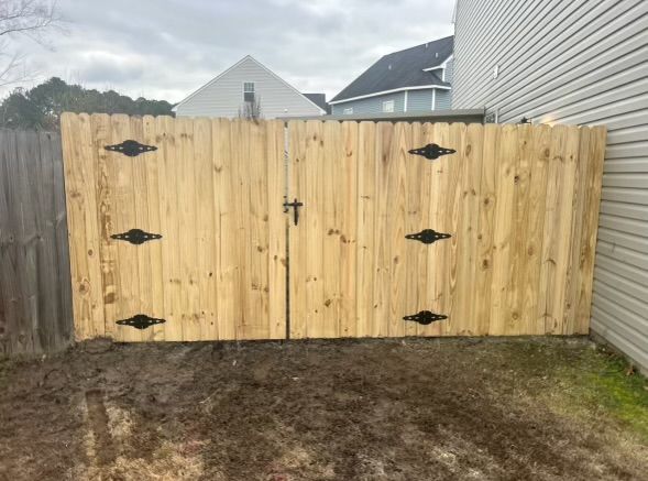 a wooden fence with a gate in the backyard of a house