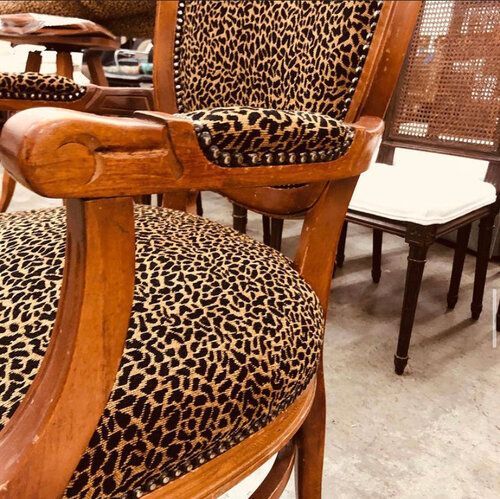 A wooden chair with a leopard print seat