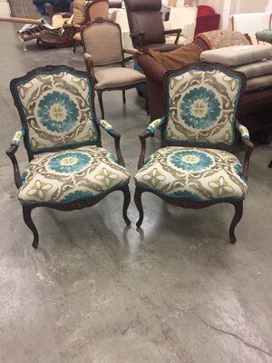 Two chairs are sitting next to each other on a concrete floor.