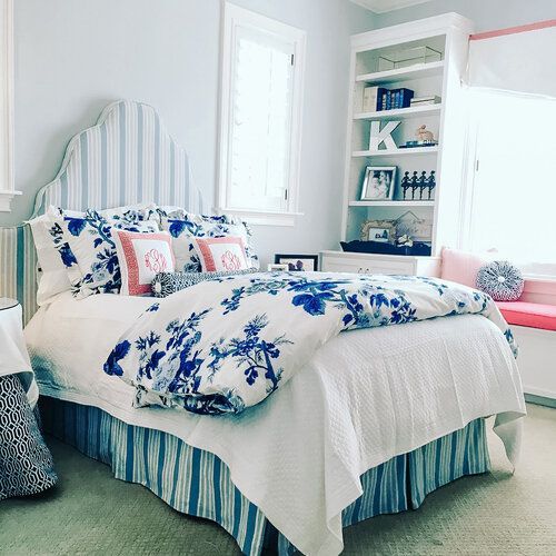 A bedroom with a bed and a bookshelf with the letter k on it.