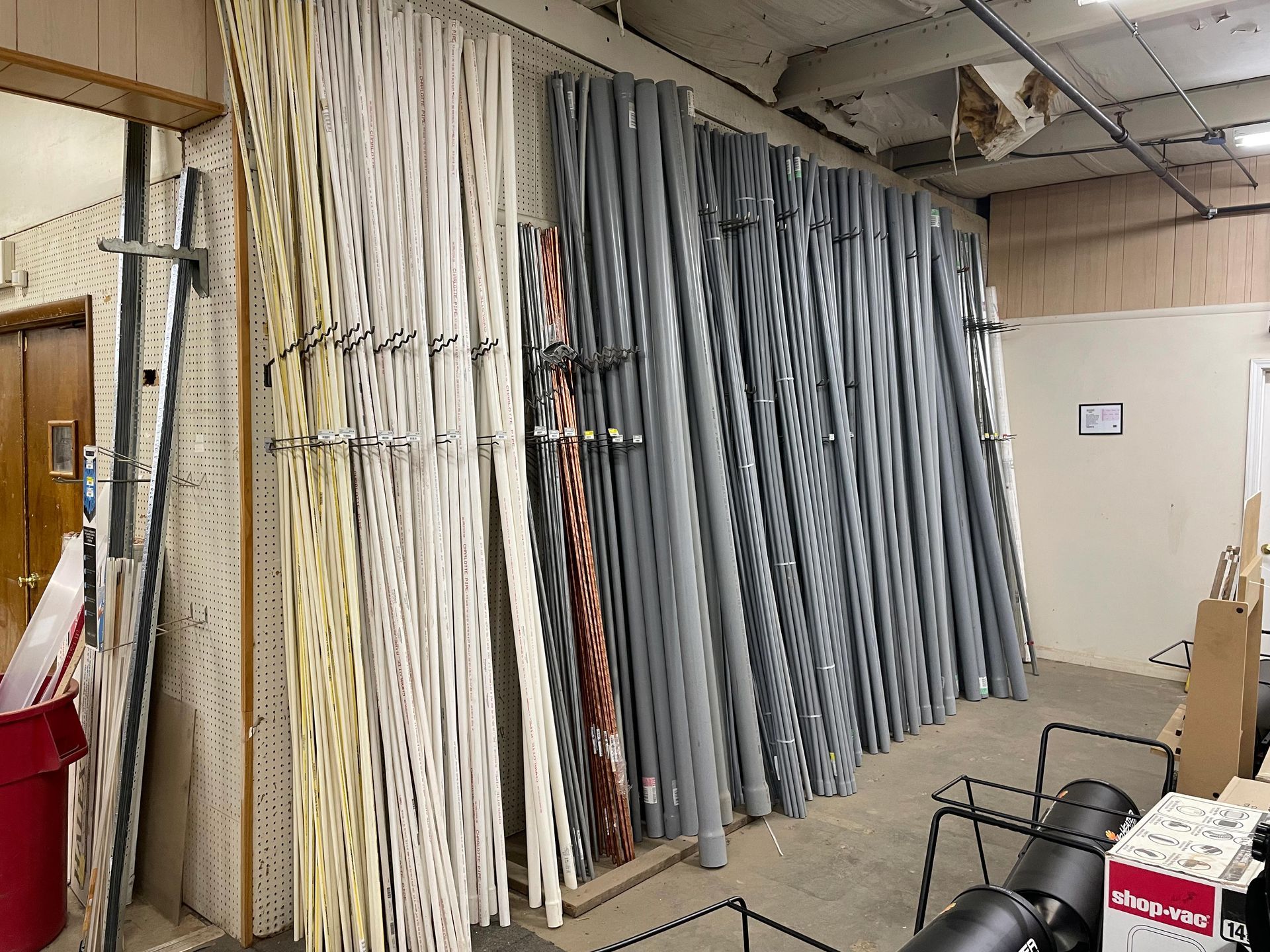 A room with a lot of pipes hanging on the wall.