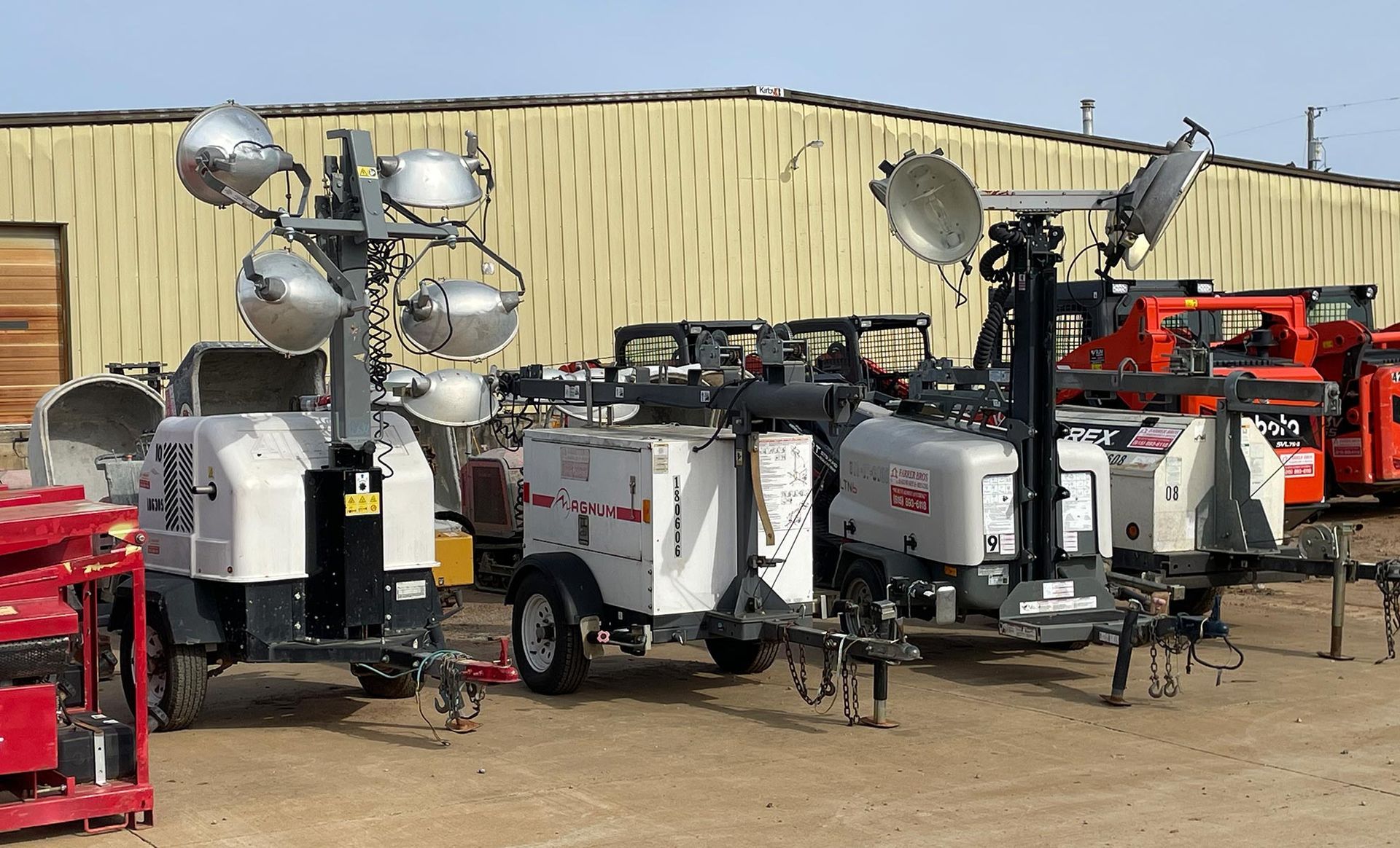 A row of trailers with lights on them are parked in front of a building.
