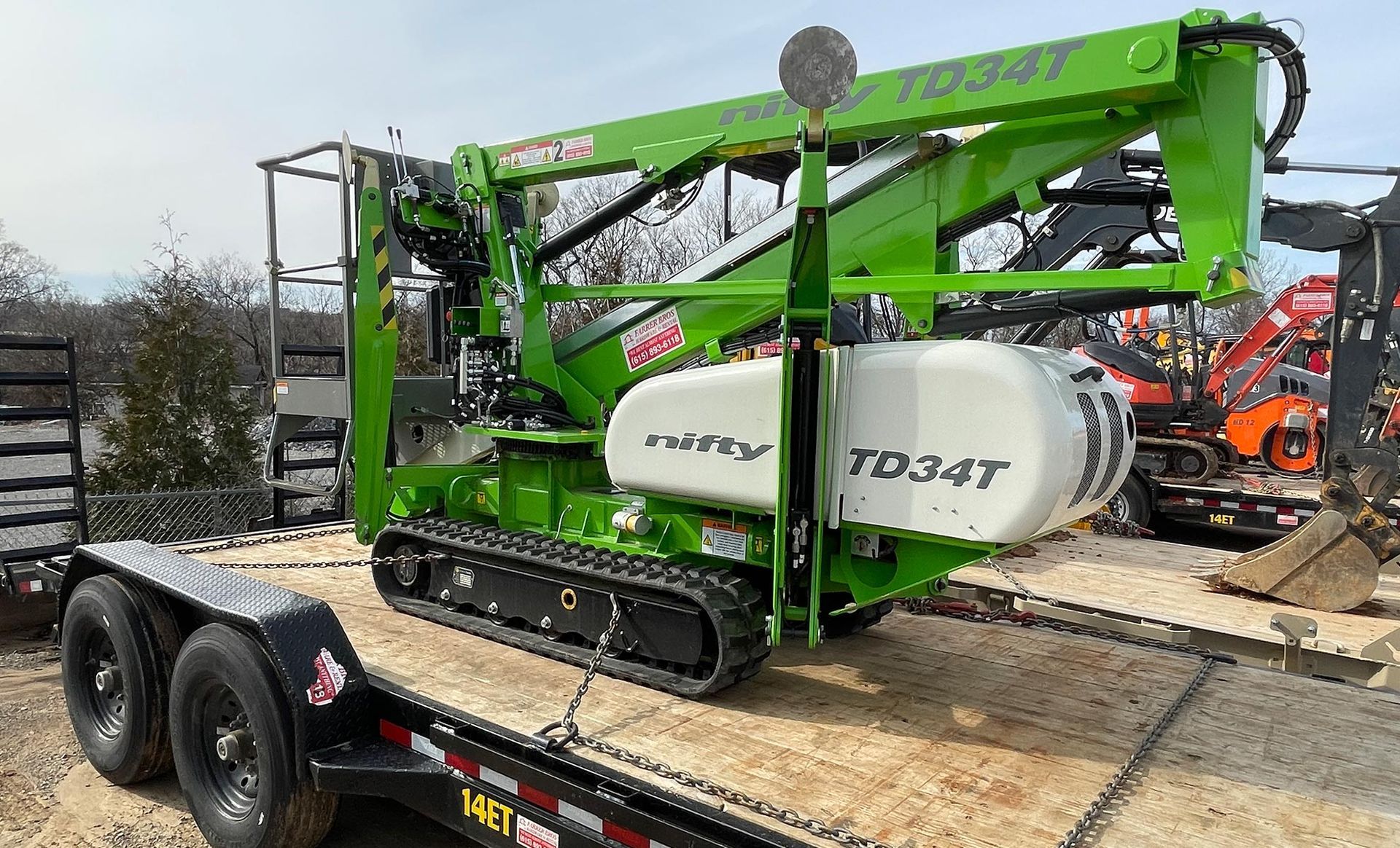 A green and white machine is sitting on top of a trailer.