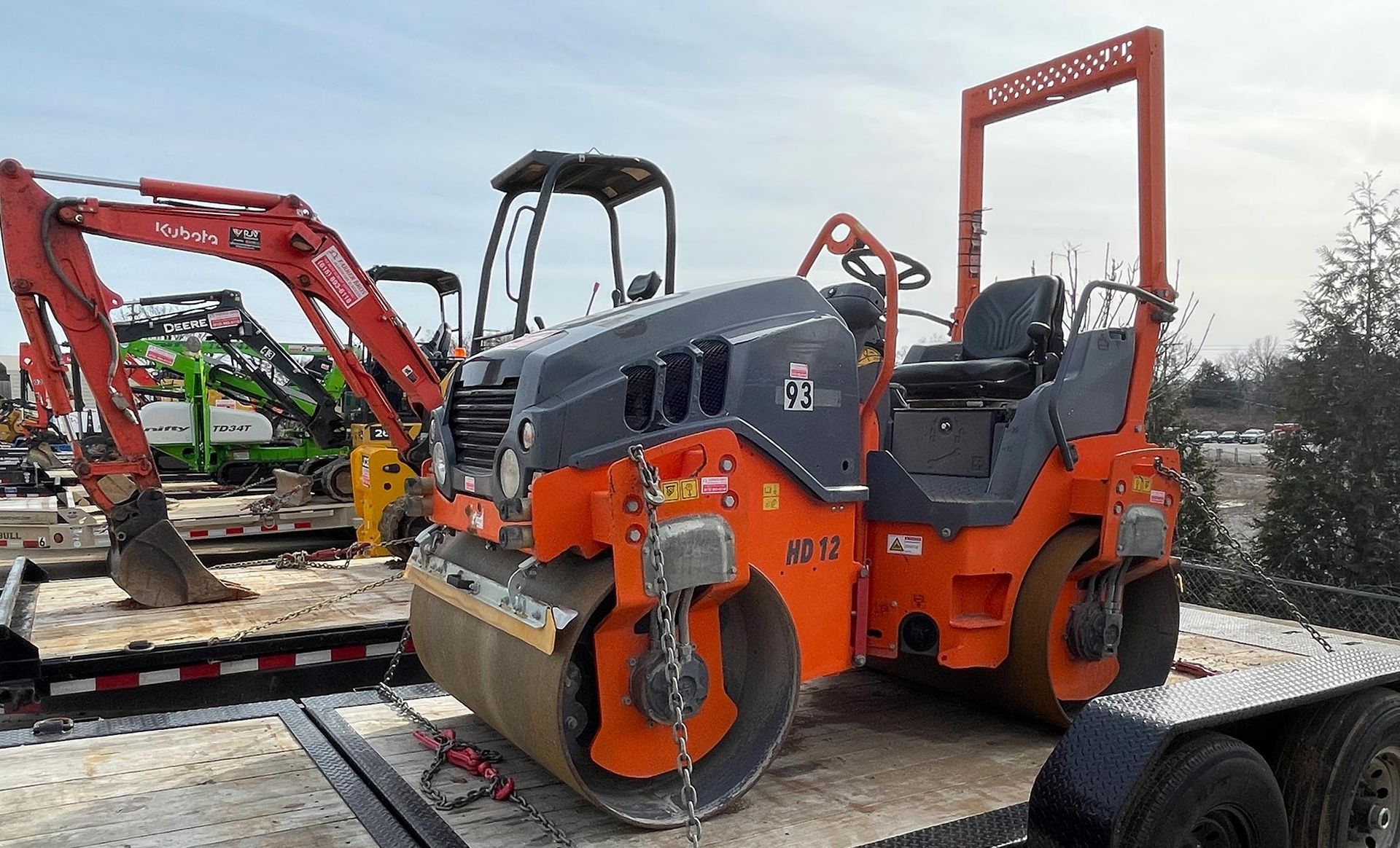 A roller is sitting on top of a trailer.