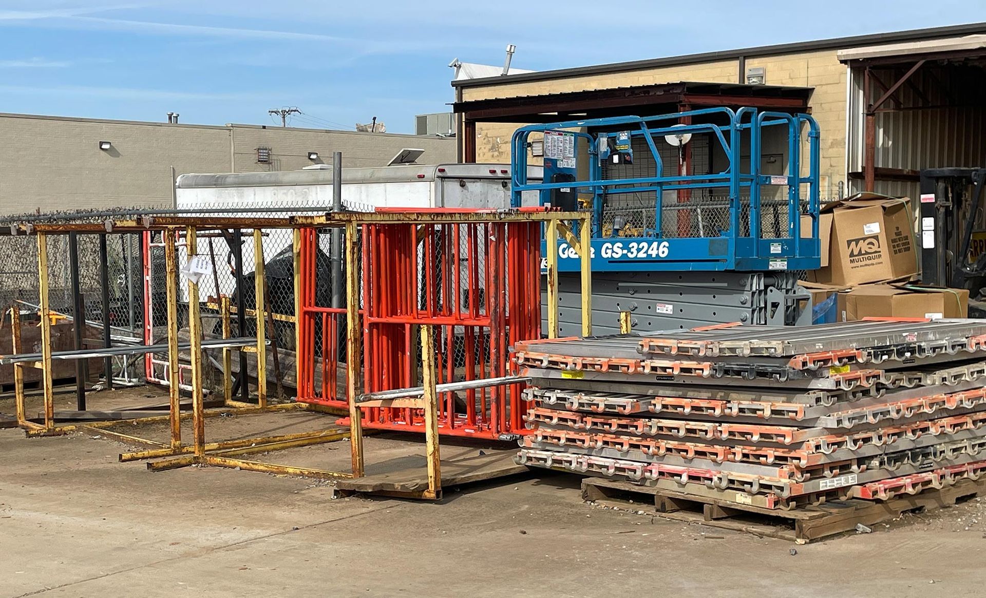 A large stack of scaffolding is sitting in front of a building.