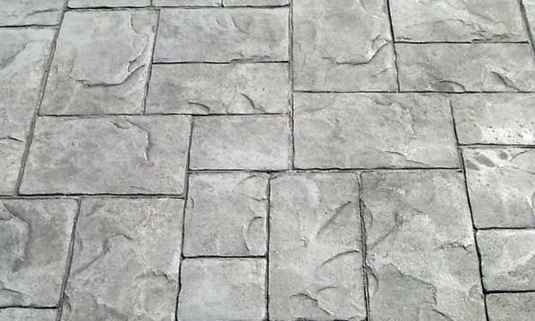 A close up of a gray brick floor with a pattern.