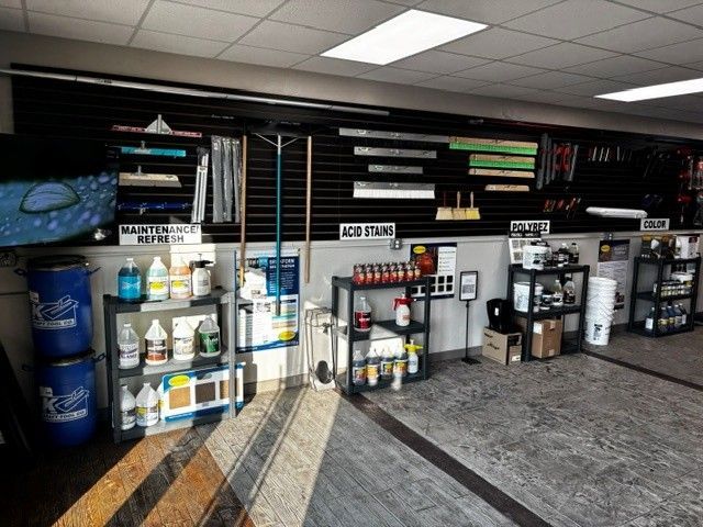 Store aisle with shelves of cleaning supplies and appliances against a black wall in a retail showroom.