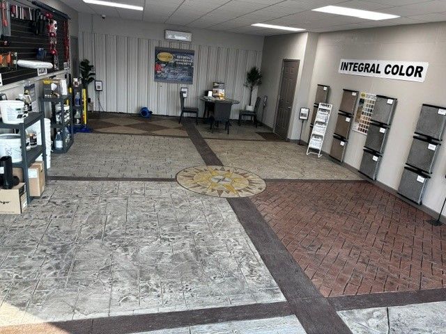 Interior paint showroom with sample flooring, display shelves, and a large “INTEGRAL COLOR” sign on the wall